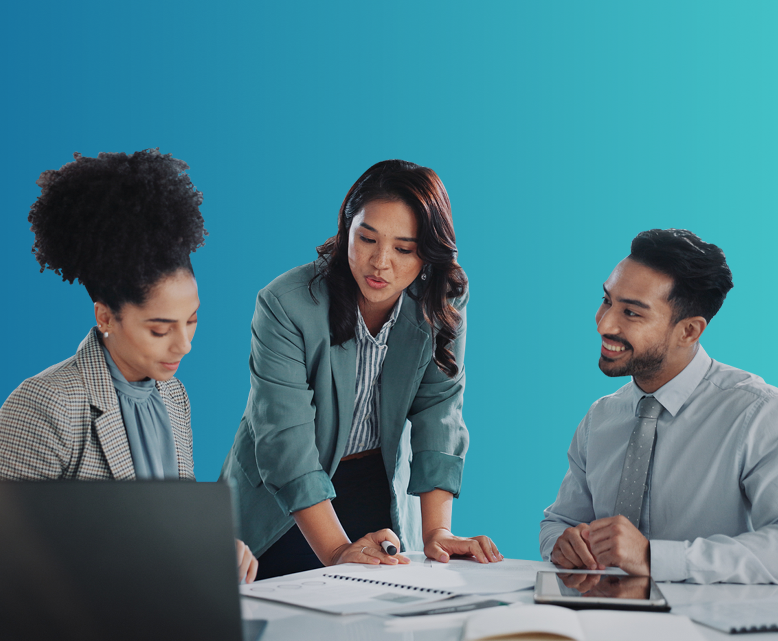 three co-workers discussing work at a table.